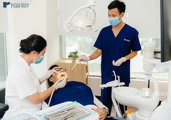 Các nha sỹ đang khám răng cho người đàn ông
