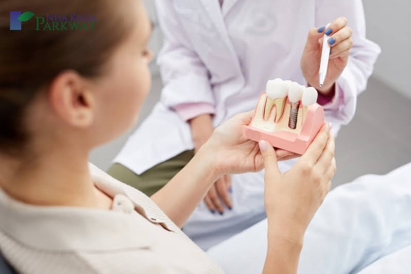 Bác sĩ giới thiệu cho cô gái mô hình trồng răng Implant