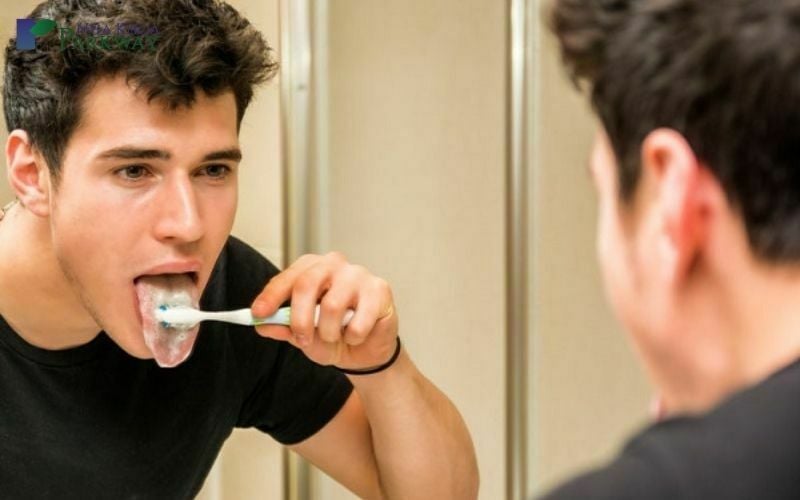 Nam thanh niên vệ sinh lưỡi bằng bàn chải đánh răng