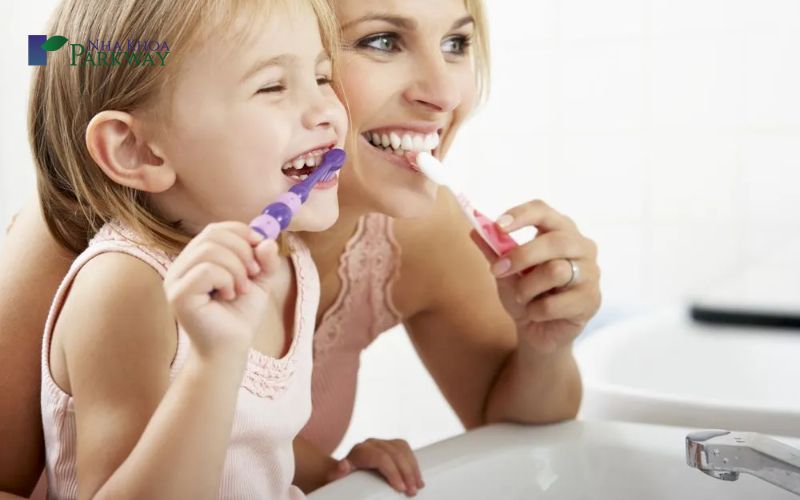 Em bé và mẹ đang cùng nhau đánh răng