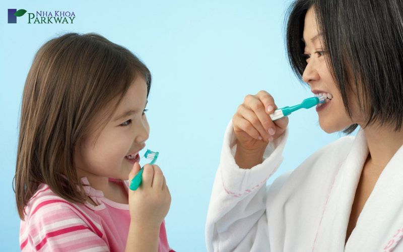 Người mẹ hướng dẫn con gái cách đánh răng