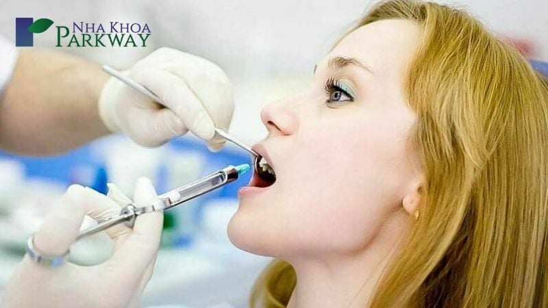 Nha sĩ dùng kim tiêm gây tê để chuẩn bị lấy tủy răng
