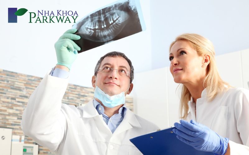 Bác sĩ đang xem ảnh chụp hàm răng của bệnh nhân để đưa ra phác đồ trồng răng phù hợp nhất