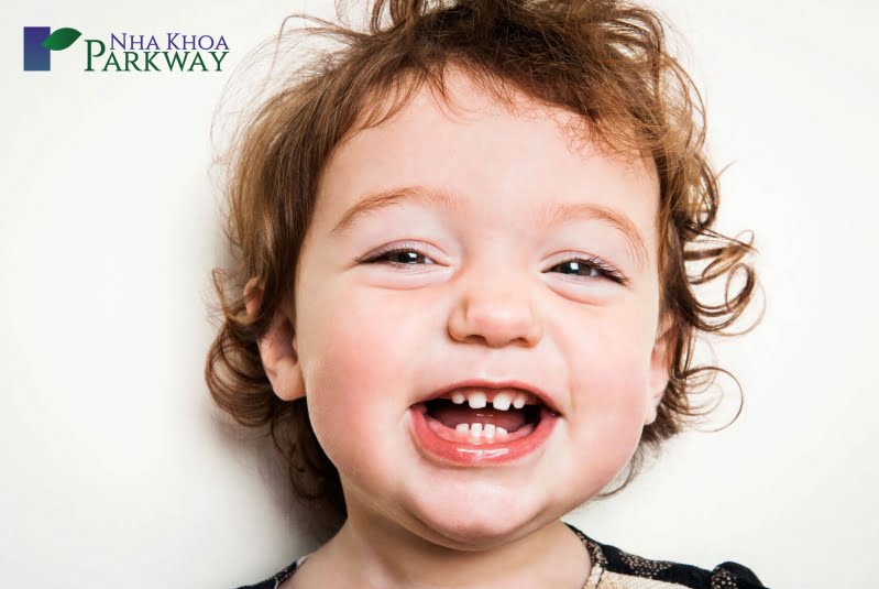 Hình ảnh em bé cười tươi với những chiếc răng sữa đáng yêu