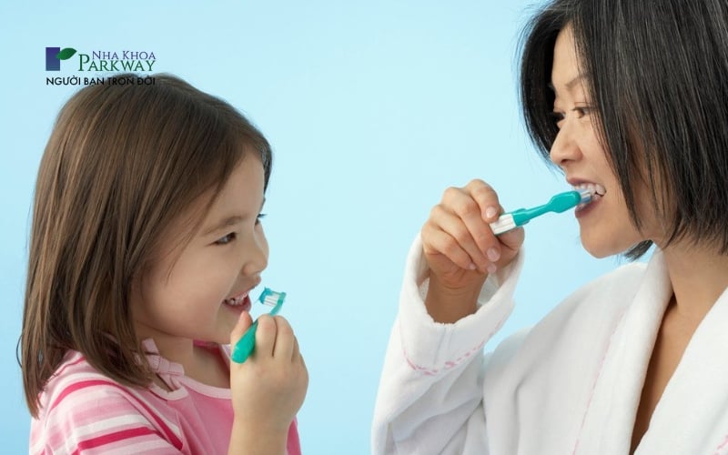 Hình ảnh người lớn hướng dẫn cho trẻ em cách đánh răng