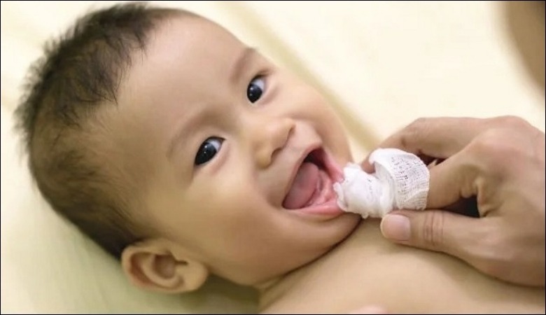 Sử dụng gạc sạch để massage nướu cho trẻ
