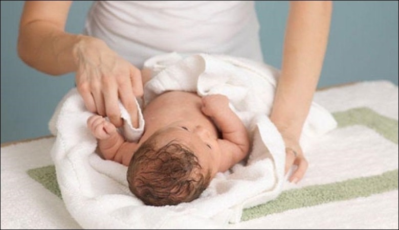 Sử dụng khăn mát để lau người cho trẻ khi sốt mọc răng